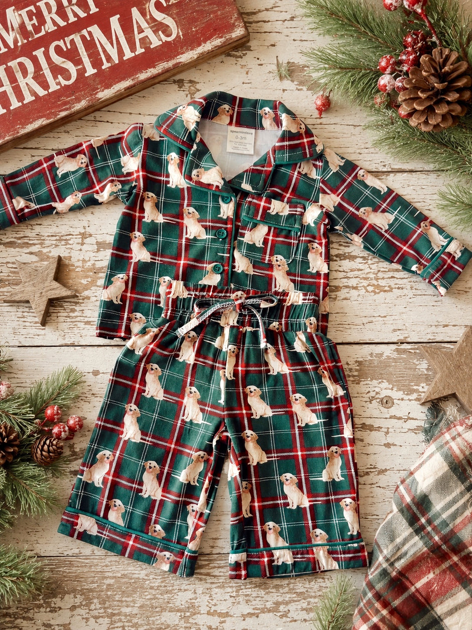 Christmas-themed children's pajamas with golden retriever print on a green plaid background, surrounded by festive decorations.