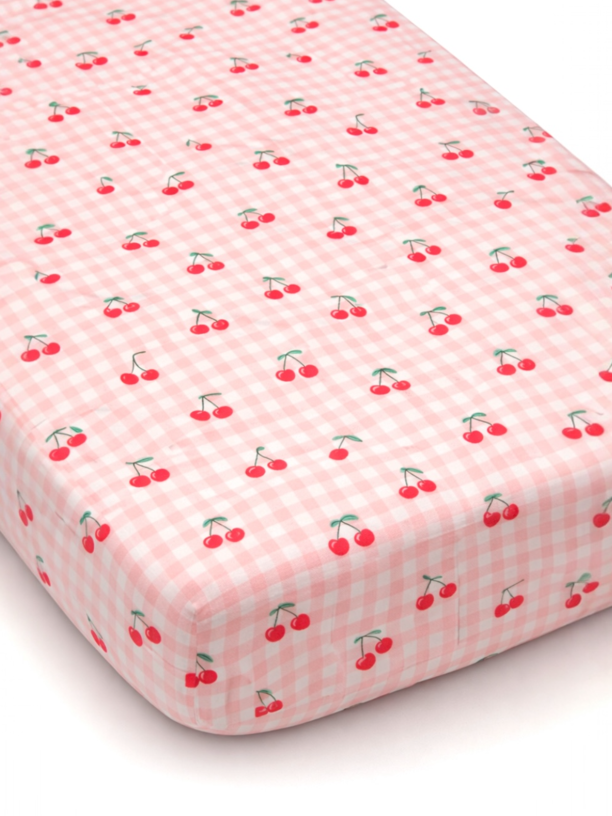 Pink crib sheet with a cherry pattern on a gingham background. Perfect for a cute nursery décor.