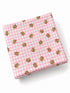 Pink gingham cloth with small teddy bear illustrations scattered across the fabric.