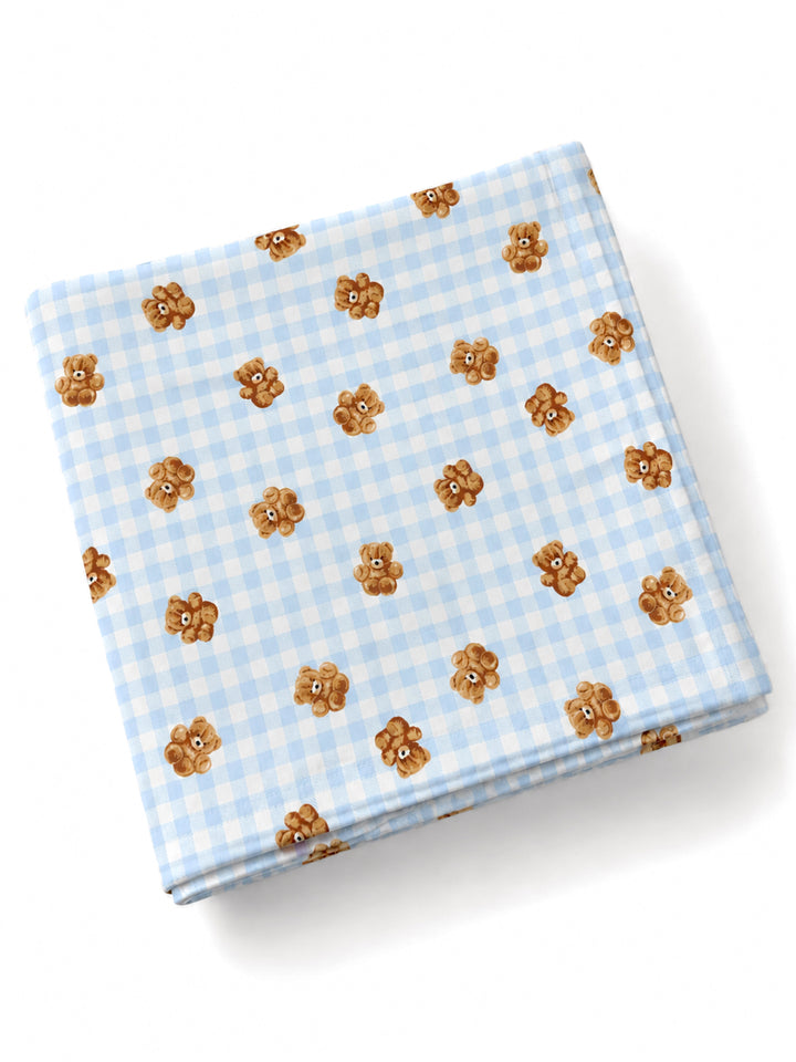 Light blue gingham fabric featuring cute teddy bear motifs scattered across the surface.