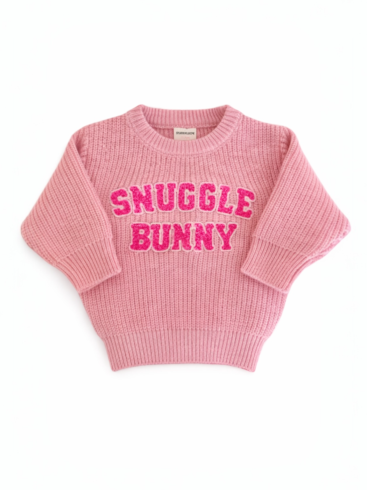 Pink sweater with "SNUGGLE BUNNY" in bold, glittery letters on the front, featuring a cozy knit design.