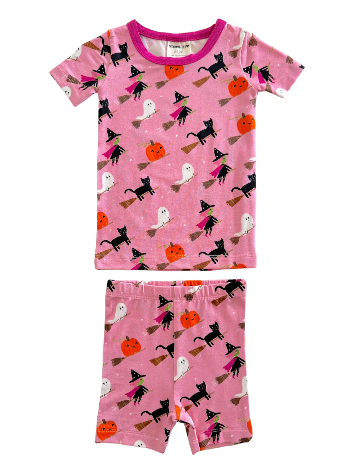 Pink Halloween-themed pajamas featuring ghosts, black cats, witches, and pumpkins on a playful pattern.