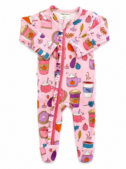 Pink baby onesie with whimsical food and drink illustrations, including cups, pumpkins, and donuts.