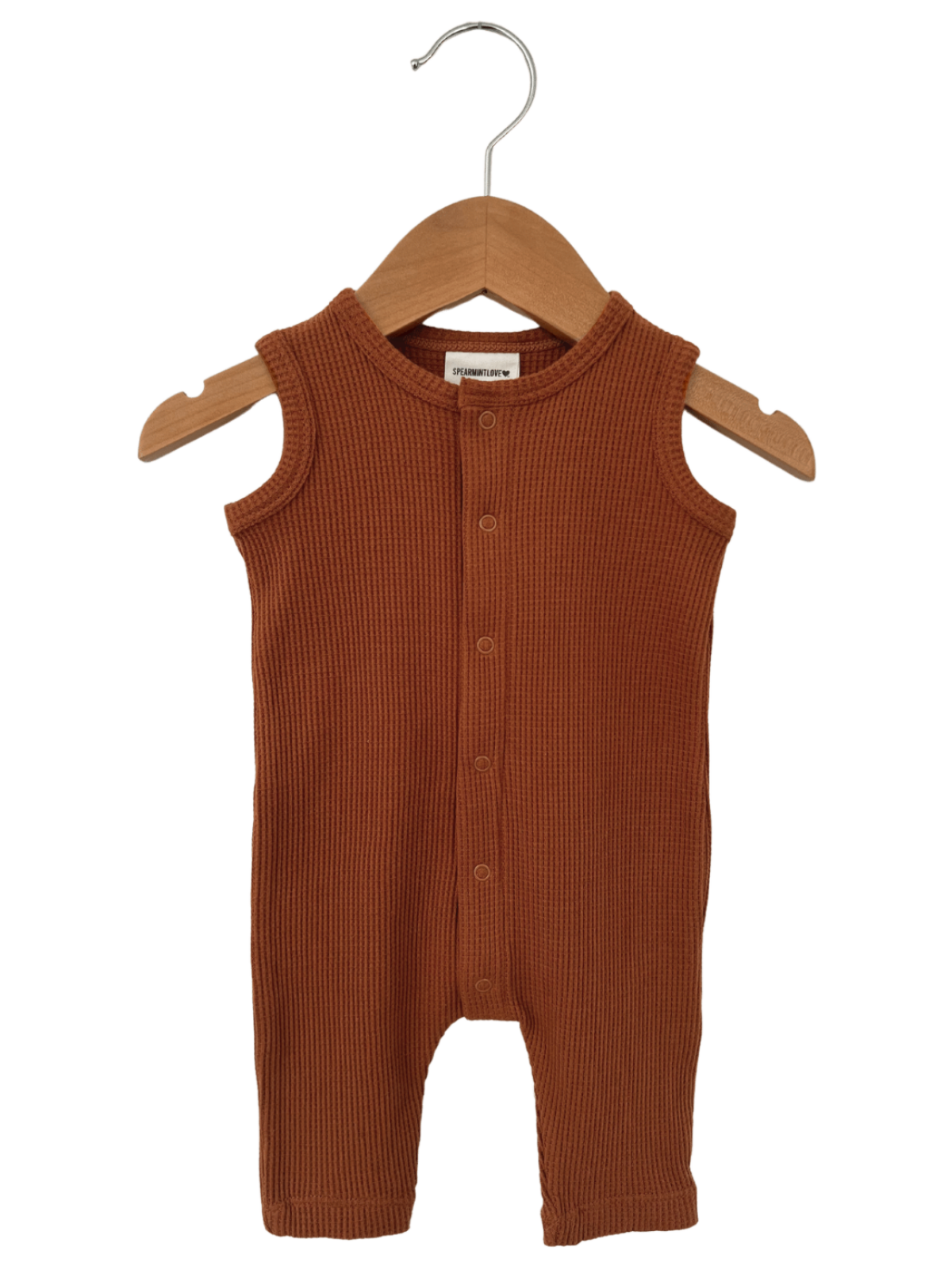 Terracotta ribbed baby romper on a wooden hanger. Perfect for casual or playtime wear.