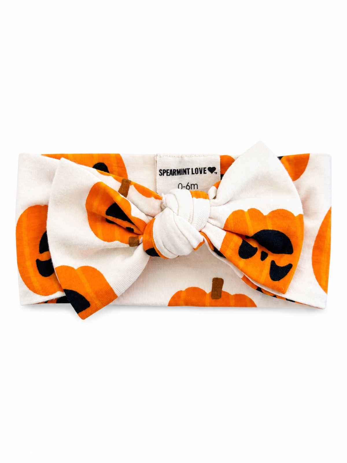 Orange pumpkin jack-o-lantern patterned baby headband with a large bow, labeled for ages 0-6 months.