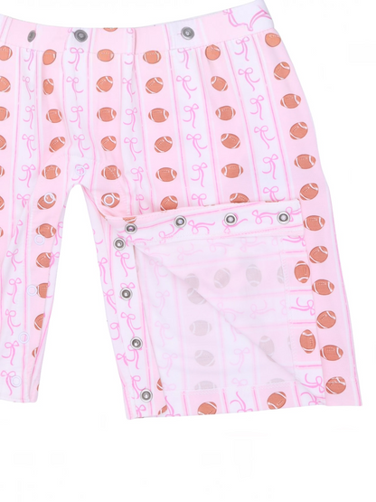 Pink shorts featuring football and bow patterns, with snap closure details on the side.