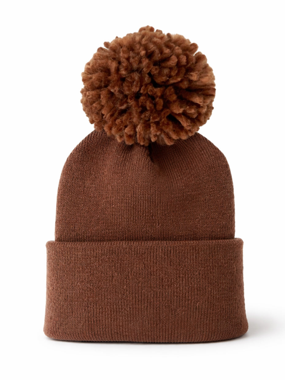 Brown knit beanie with a large pom-pom on top, perfect for cold weather.