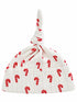 White baby hat with a knot on top, adorned with red candy cane patterns.