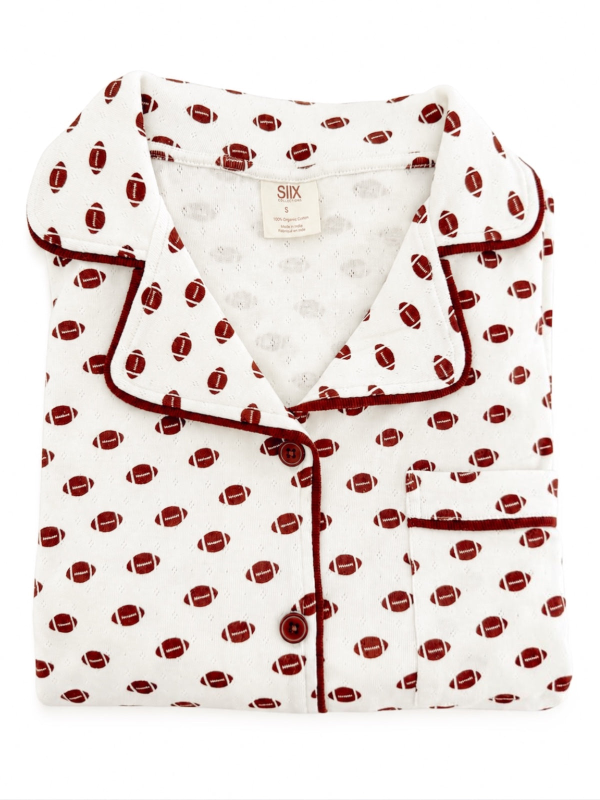 Folded white pajamas with red football prints and maroon piping, showcasing a classic design.