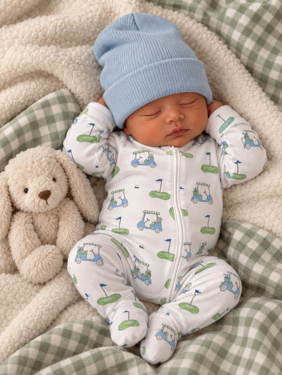 Baby peacefully sleeping in a cozy onesie with golf designs, cuddling a soft bunny on a plush blanket.