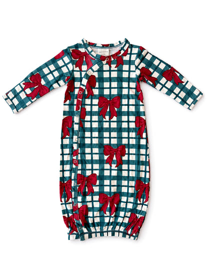 Green and white plaid infant gown with red bow print and side snap buttons. Ideal for cozy, festive wear.