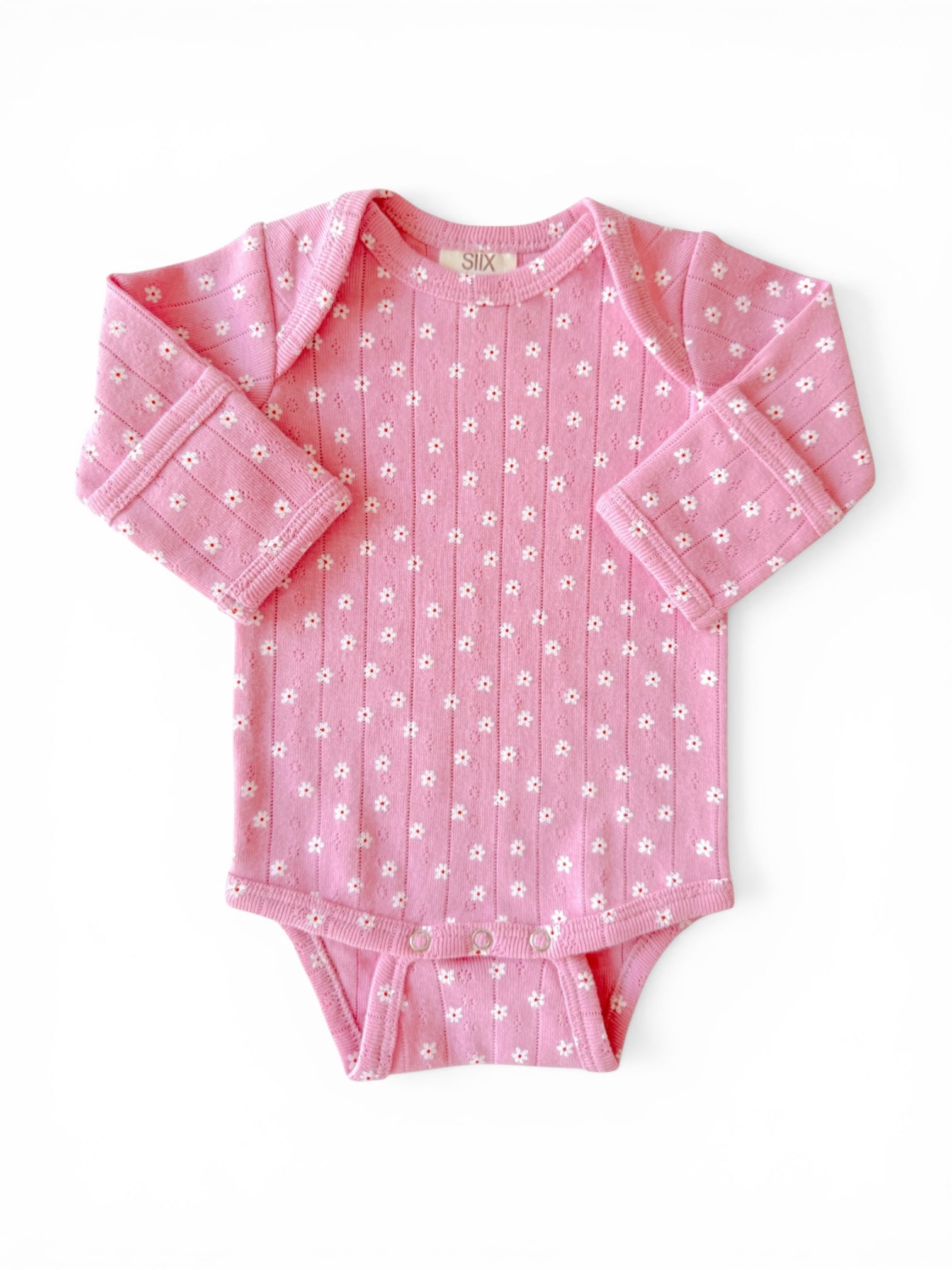 Pink baby onesie with floral pattern, long sleeves, and snap closures at the bottom on a white background.