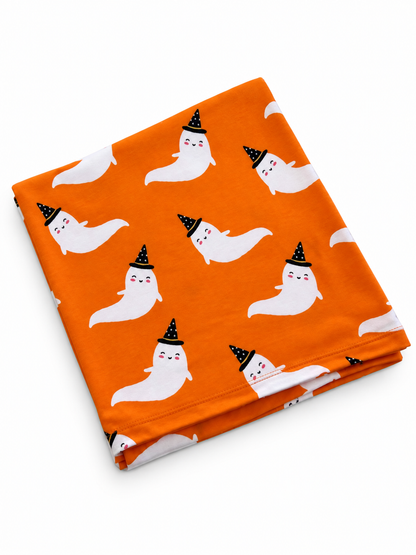 Orange fabric featuring playful ghost patterns wearing black witch hats. Perfect for Halloween decor or projects.