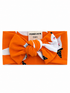Orange baby headband with a large bow and fox print, labeled "Spearmint Love 0-6m."