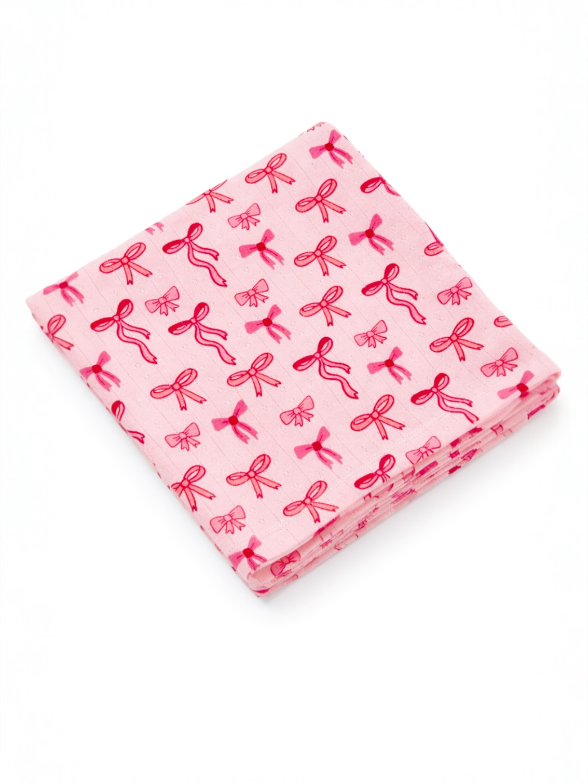 Pink fabric square featuring a repeated pattern of red bows on a light background.