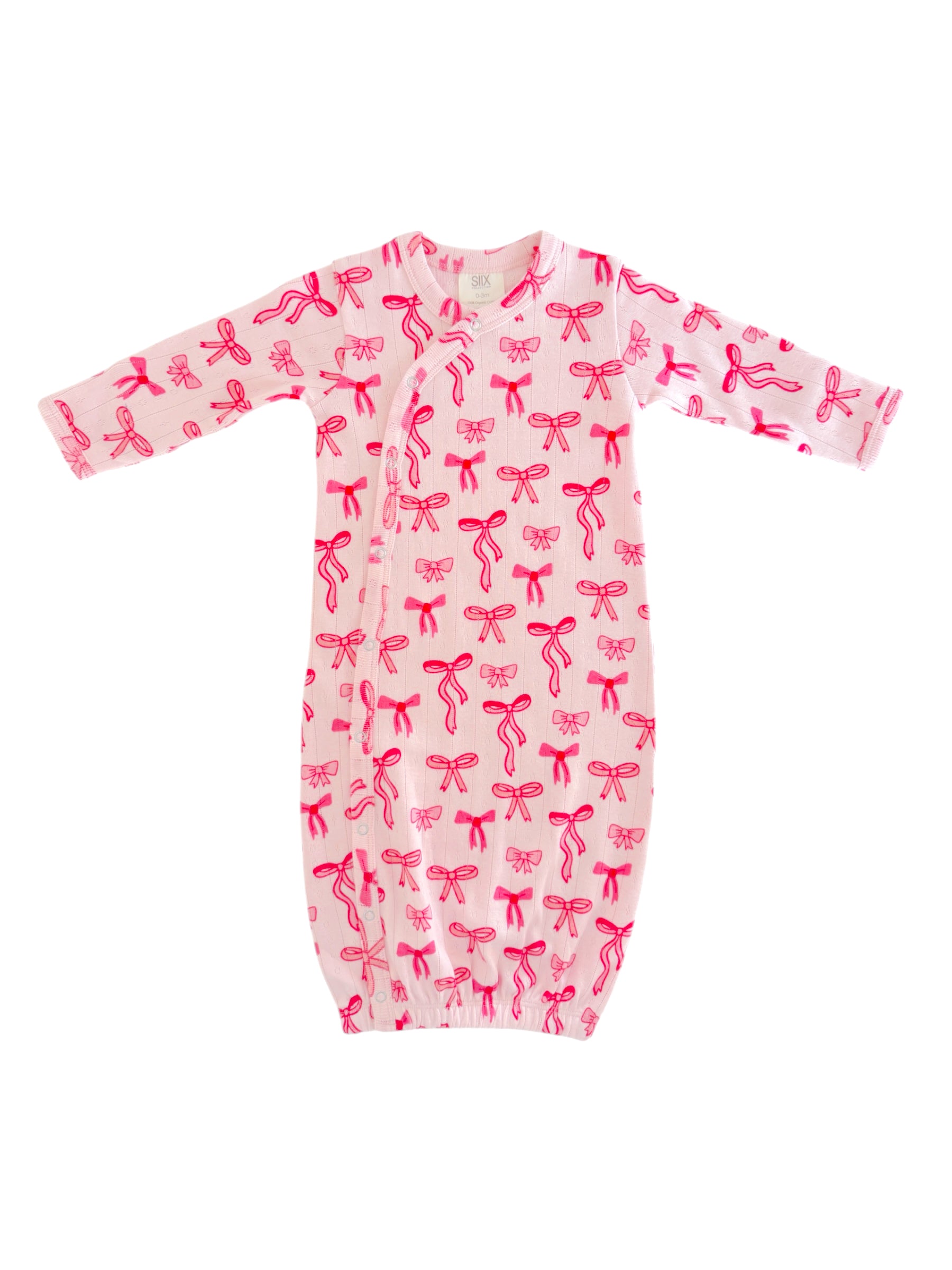 Light pink infant gown with red bow patterns, featuring long sleeves and a gathered bottom for easy dressing.
