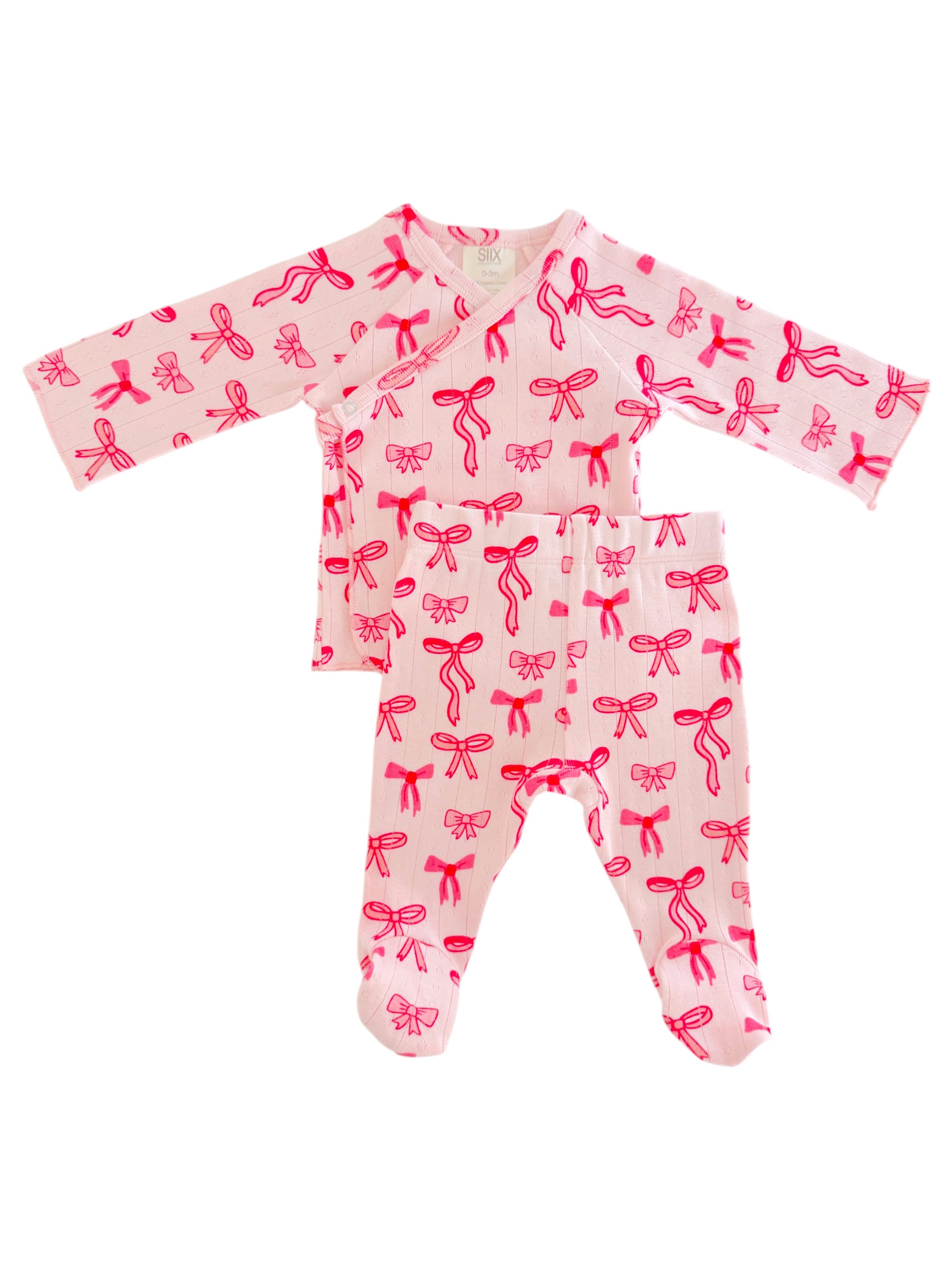 Pink baby outfit with long sleeves and bows pattern, featuring a top and matching bottom. Perfect for infants.