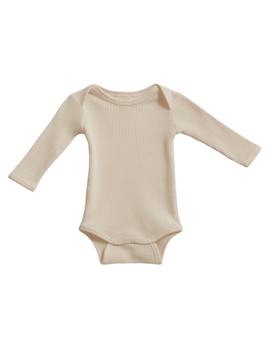 Light beige long-sleeve baby bodysuit displayed flat. Soft, ribbed texture, suitable for infants.