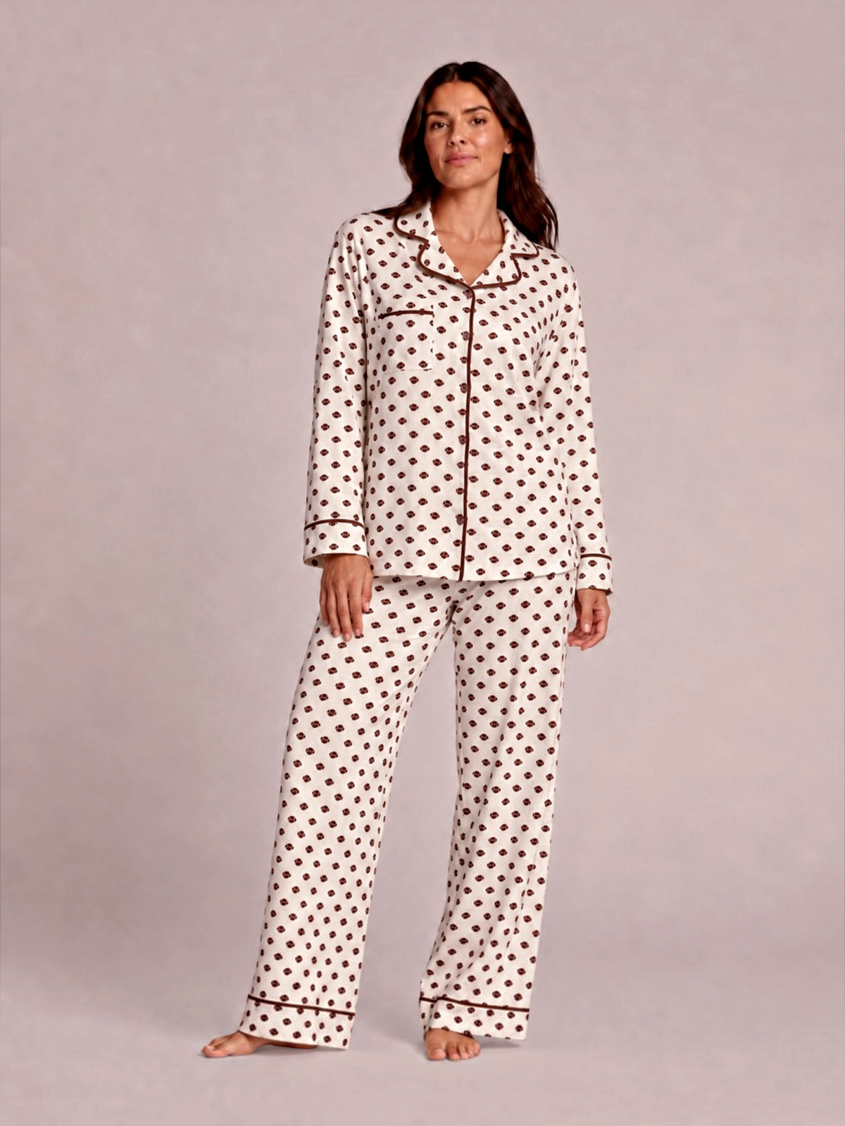 Woman in polka dot pajamas poses confidently against a light background. Casual, cozy sleepwear fashion.