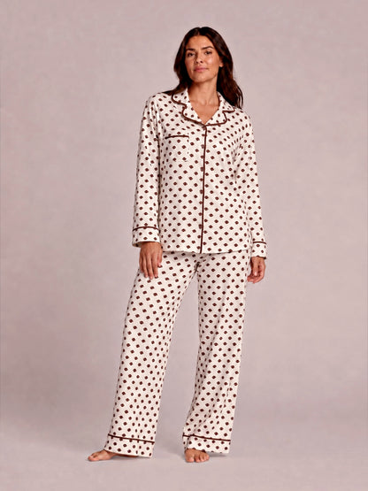 Woman in polka dot pajamas poses confidently against a light background. Casual, cozy sleepwear fashion.