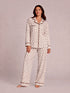 Woman in polka dot pajamas poses confidently against a light background. Casual, cozy sleepwear fashion.
