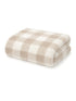 Folded beige and white checkered blanket on a white background. Soft, cozy fabric texture visible.