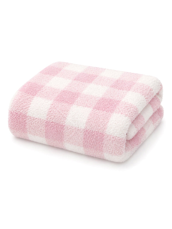 Soft pink and white checkered towel folded neatly. Ideal for cozy home decor or bath use.