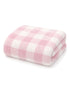 Soft pink and white checkered towel folded neatly. Ideal for cozy home decor or bath use.