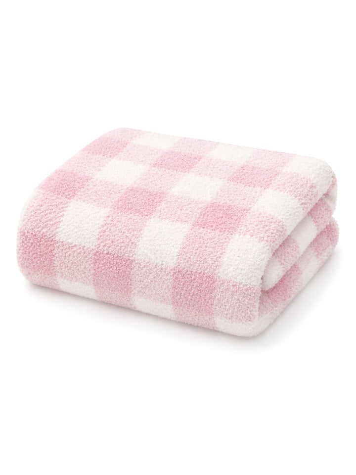 Soft pink and white checkered towel folded neatly. Ideal for cozy home decor or bath use.