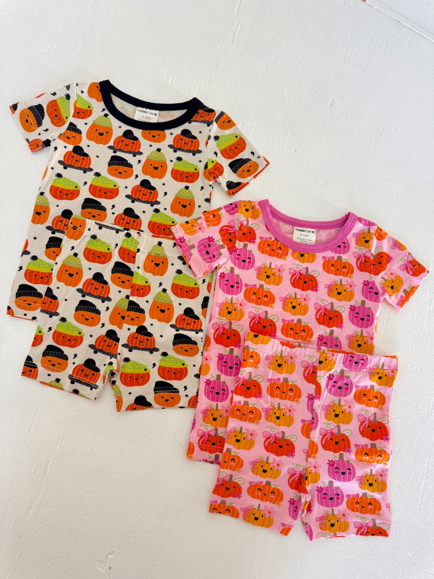 Two sets of toddler pajamas featuring colorful pumpkin designs, ideal for Halloween festivities.