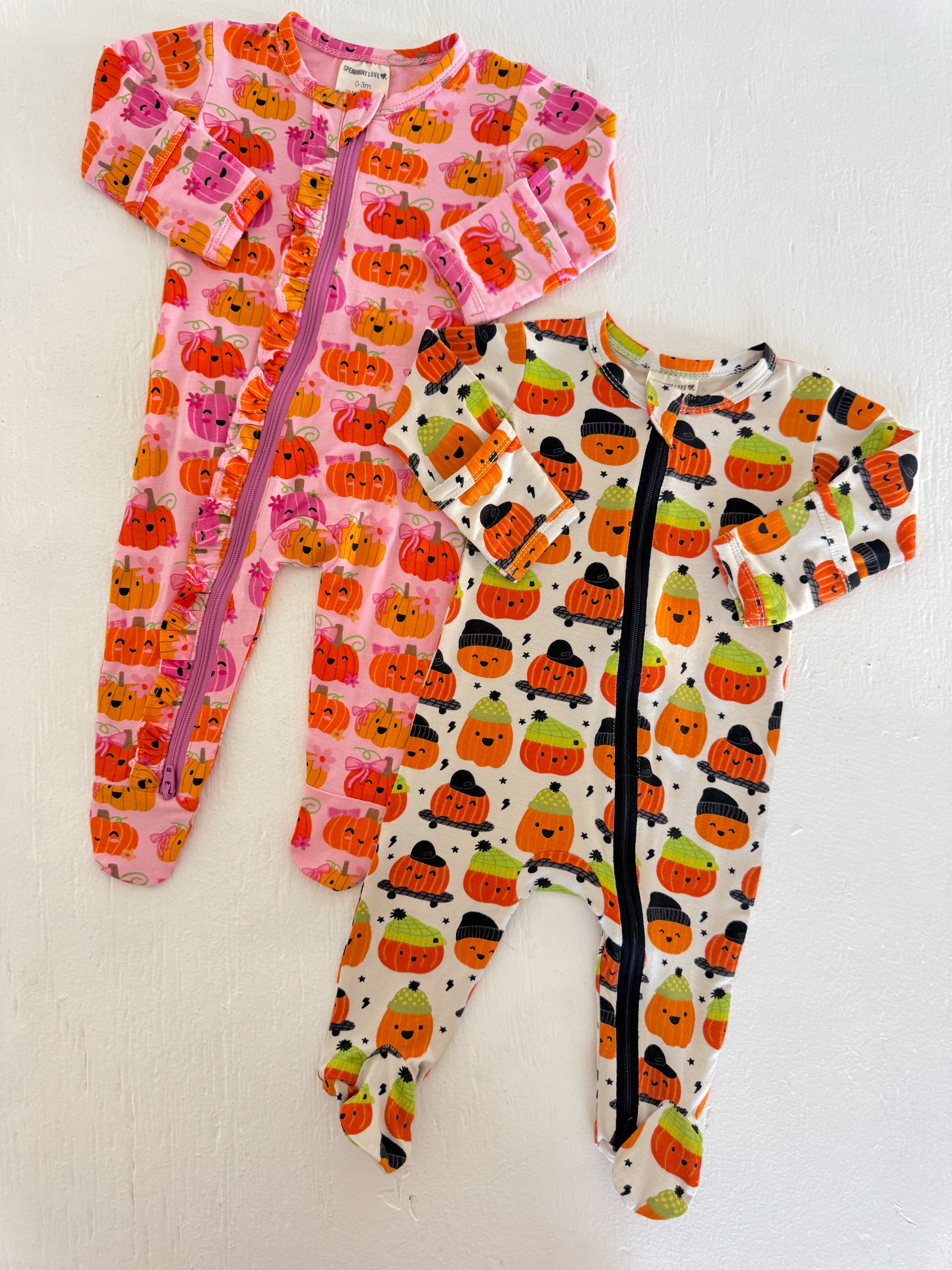 Two playful pumpkin-themed toddler pajamas in pink and white. Perfect for cozy fall nights.