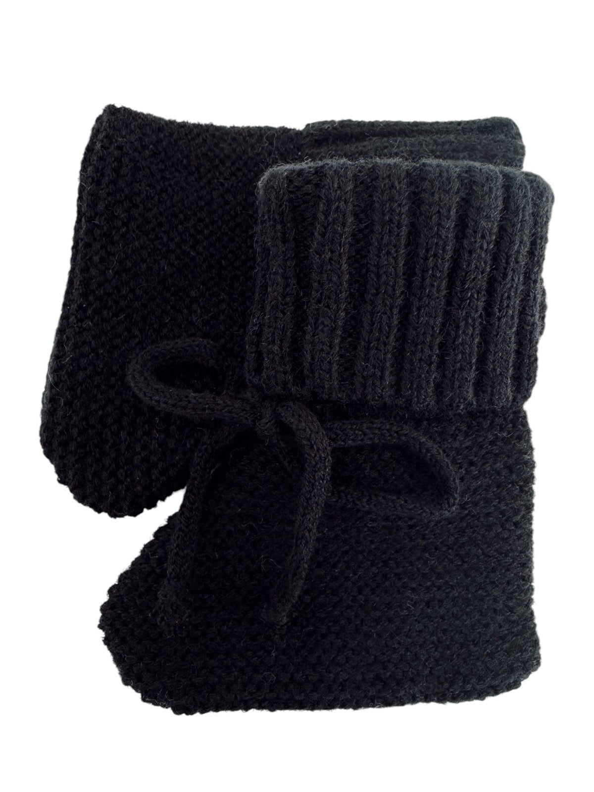 Black knitted slippers with a ribbed cuff and bow detail. Ideal for warmth and comfort at home.