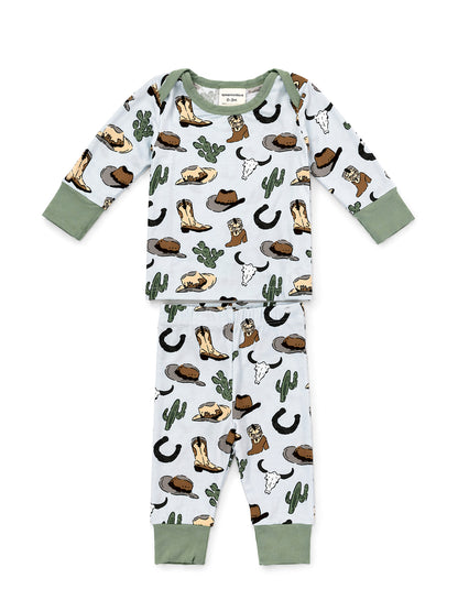 Toddler sleepwear set featuring cowboy-themed patterns: hats, boots, cacti, and skulls on light blue fabric.