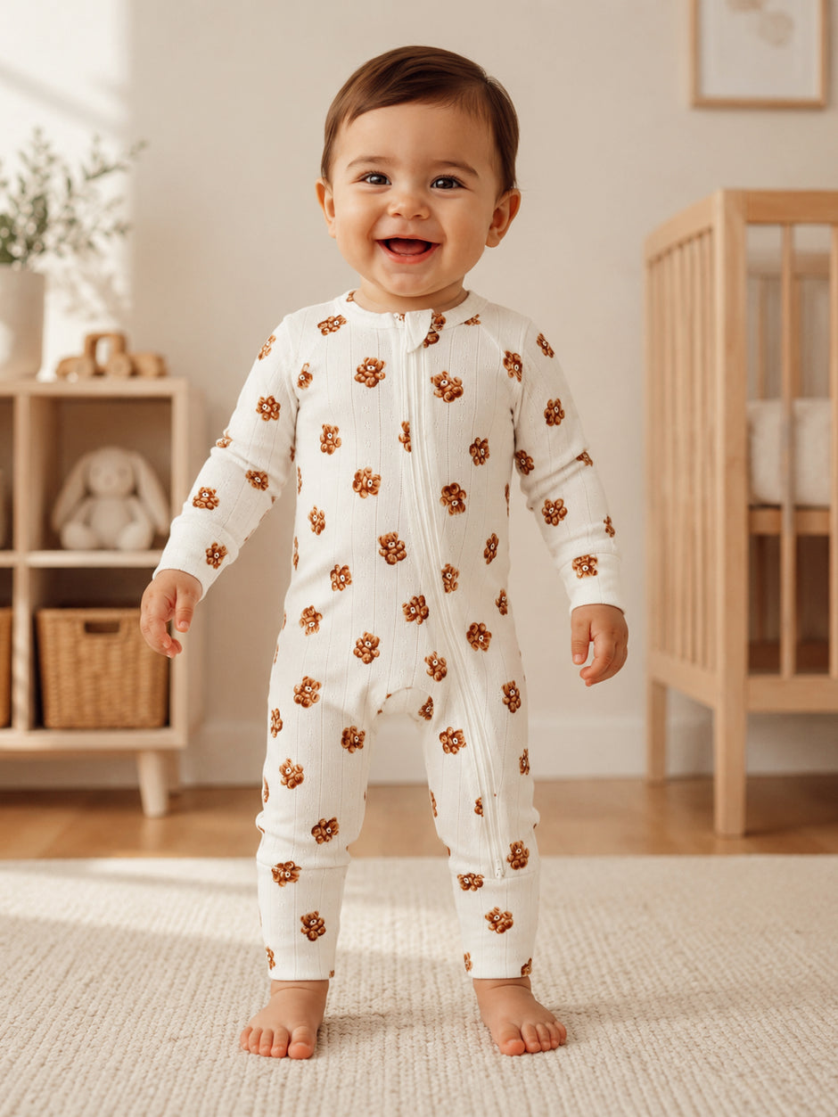 Smiling toddler in a floral onesie stands in a bright, cozy nursery. Natural light highlights playful decor.