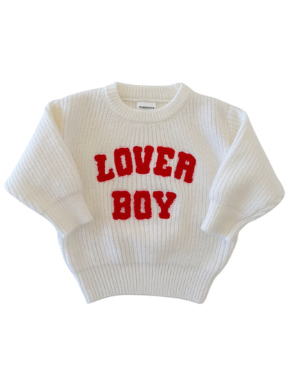 White knitted sweater with red "LOVER BOY" text on the front, featuring a cozy, oversized fit.