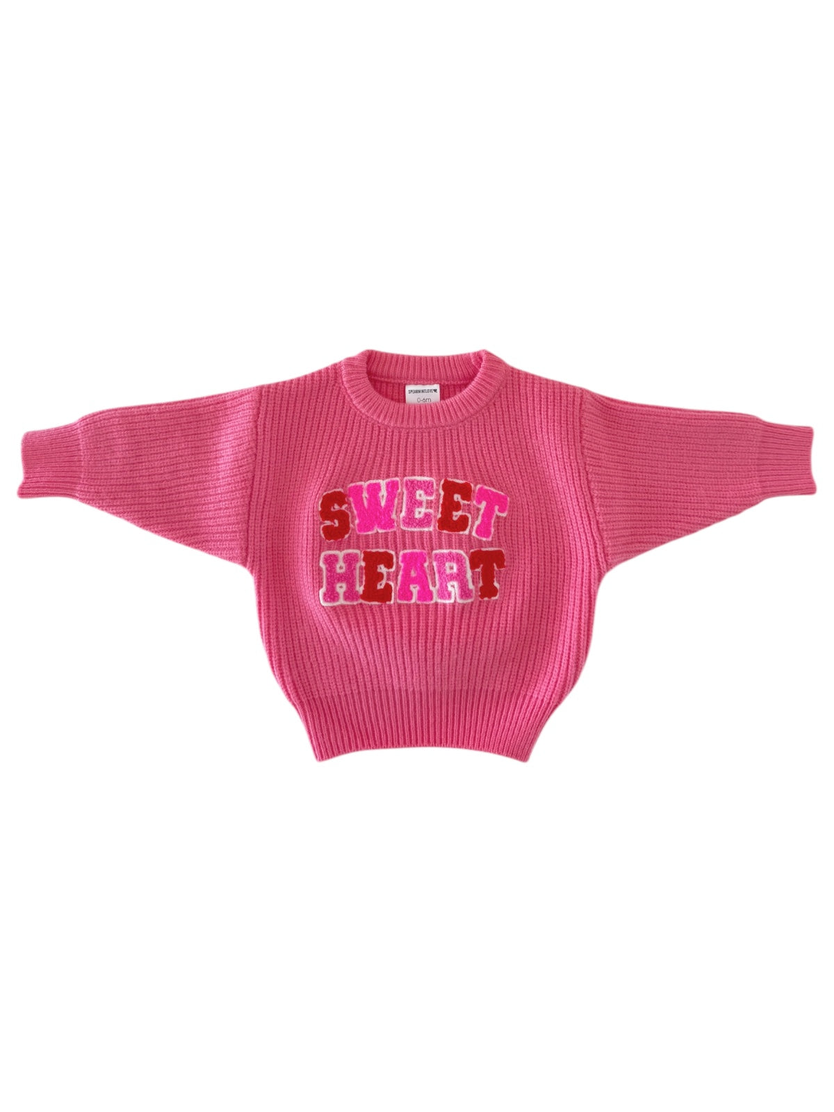 Pink sweater with "SWEET HEART" graphic in red and pink letters, featuring a ribbed texture and wide sleeves.
