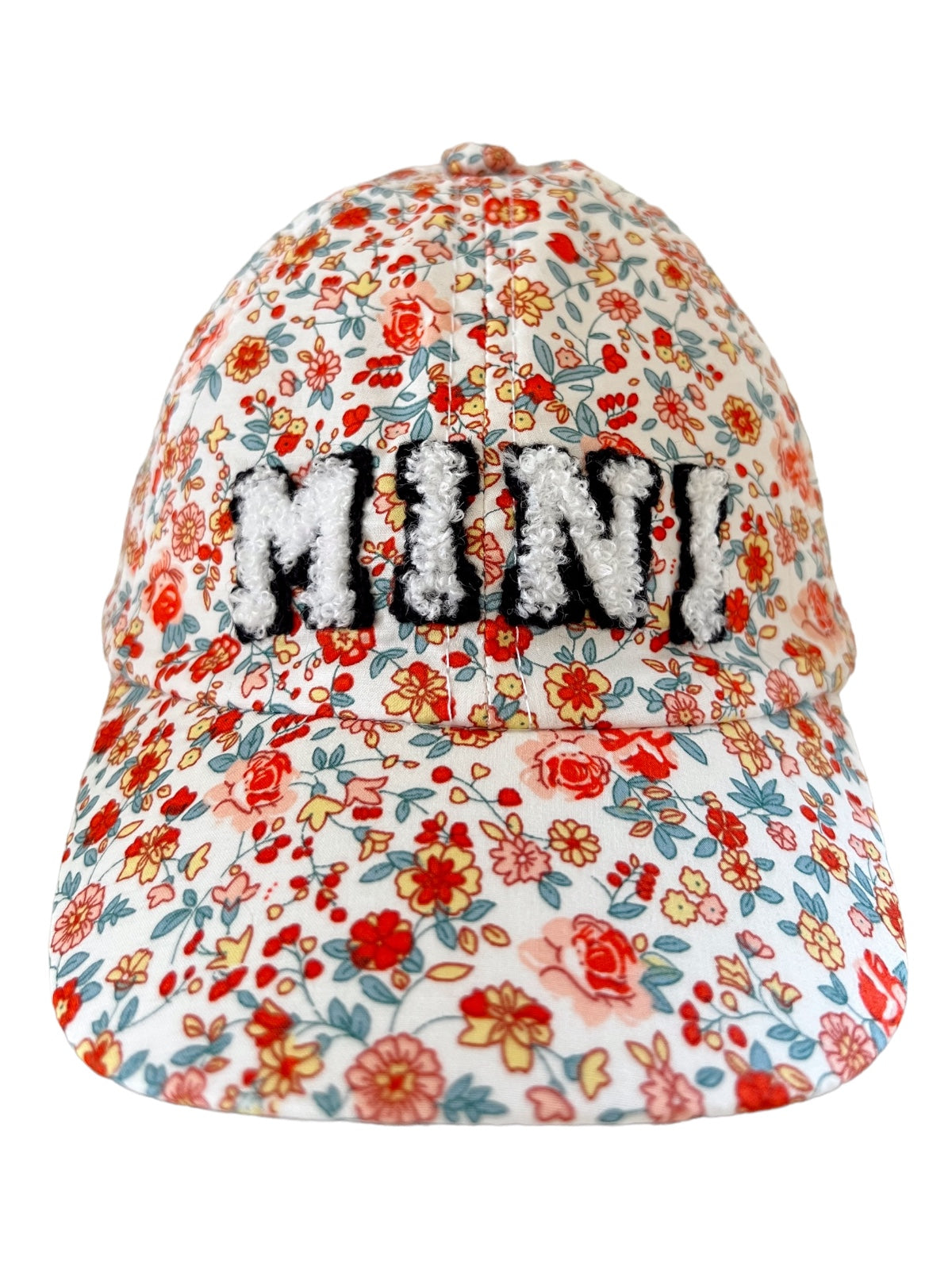 Floral print baseball cap with the word "MINI" in fluffy black letters on the front.