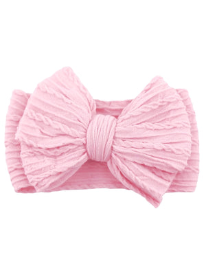 Pink textured hair bow with a knotted center, placed on a soft headband.