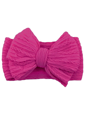 Bright pink textured headband with a large bow in the center, perfect for fashion accessories or hair styling.