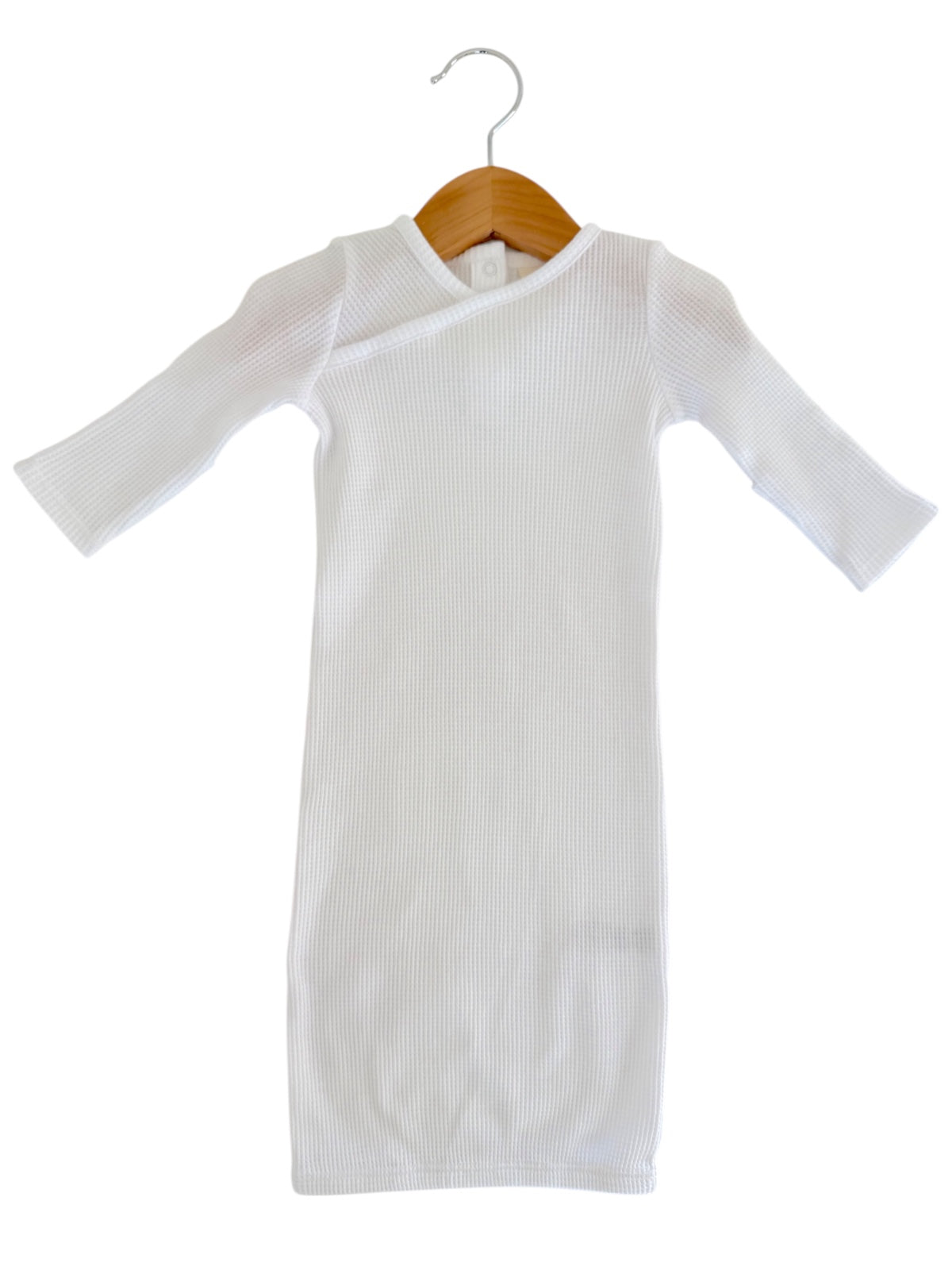 White ribbed long-sleeve dress displayed on a wooden hanger against a white background.