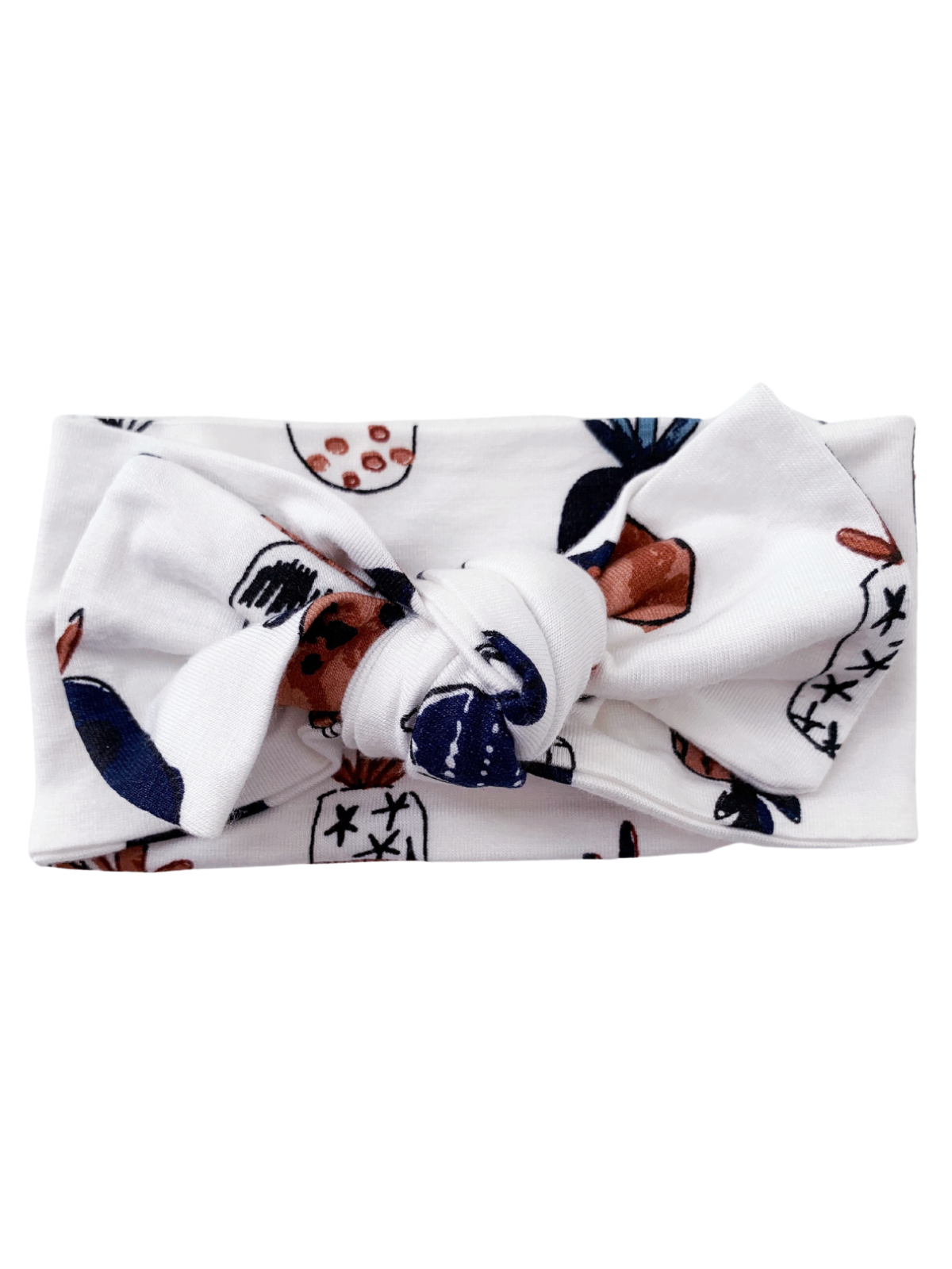 White headband with a knotted design, featuring colorful fruit and floral patterns.