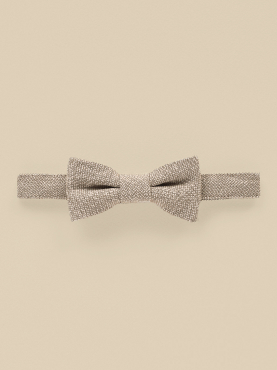 Beige bow tie on a light background, showcasing a textured fabric design. Perfect for formal occasions.