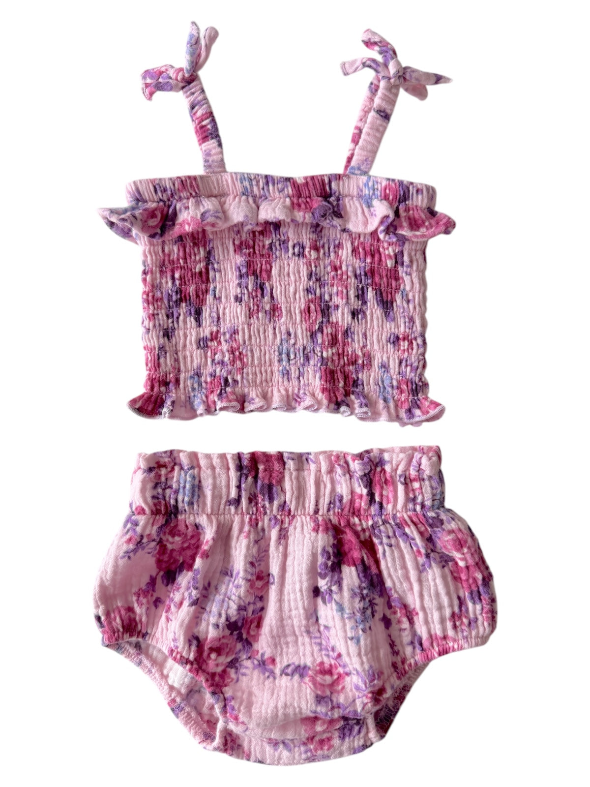 Floral two-piece outfit featuring a smocked top and ruffled shorts in shades of pink and purple.
