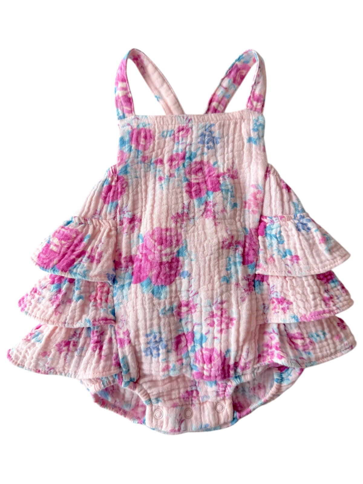 Floral baby romper with ruffled layers in pink and blue, featuring crisscross straps and snap closures at the bottom.