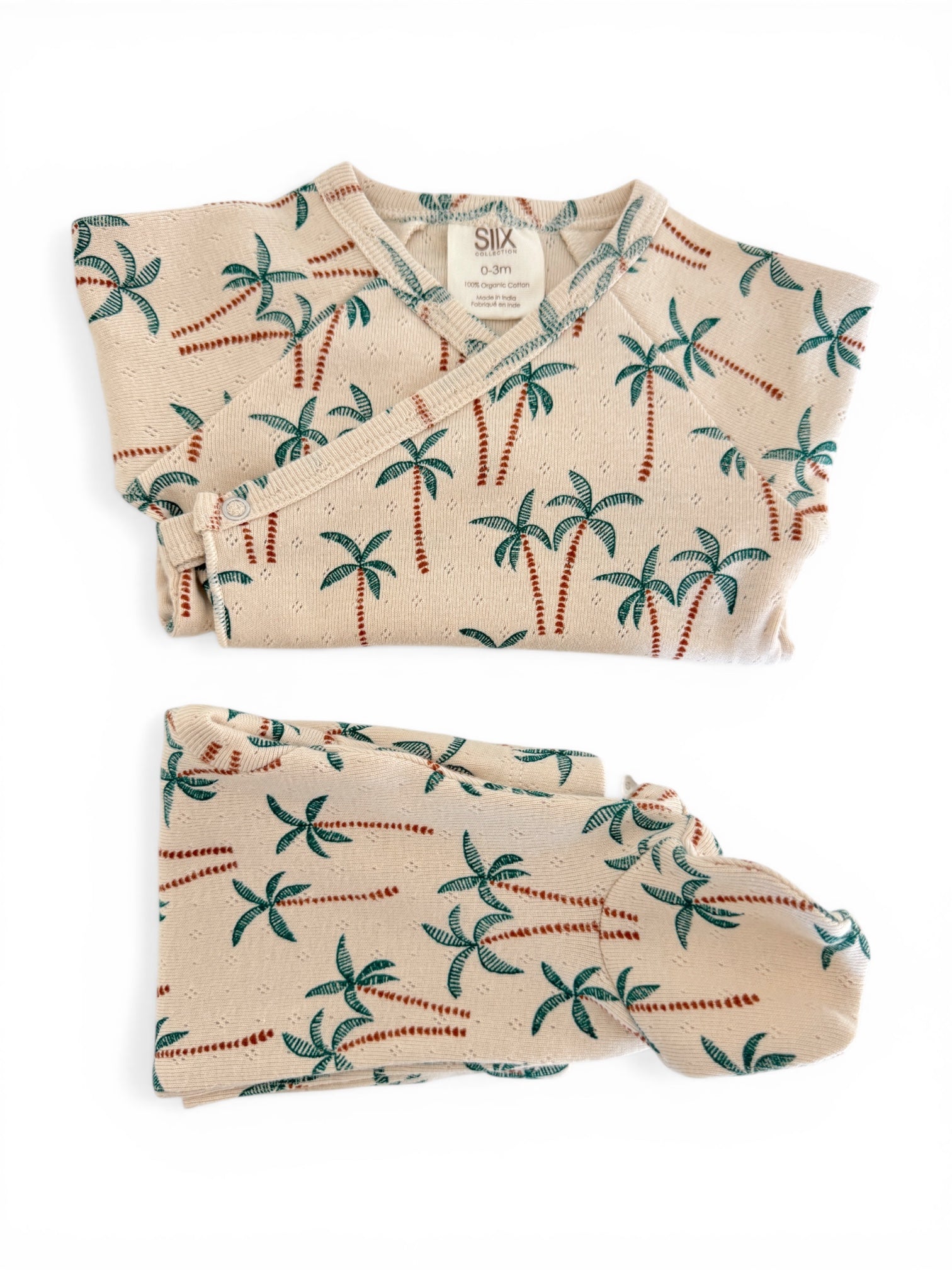 Organic cotton infant outfit with palm tree pattern, featuring a wrap top and matching pants.