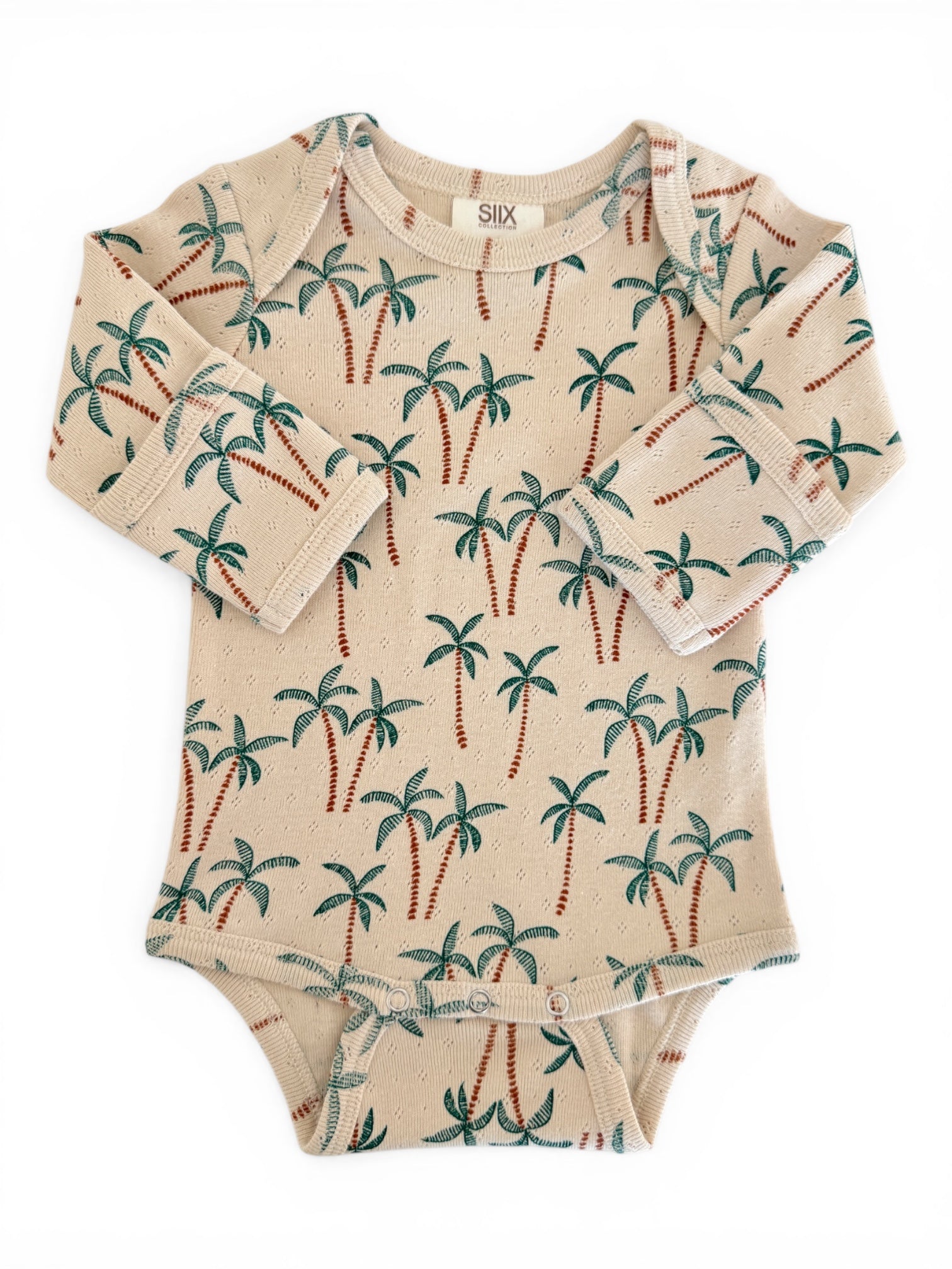 Beige baby bodysuit with palm tree print, featuring long sleeves and snap buttons at the bottom.