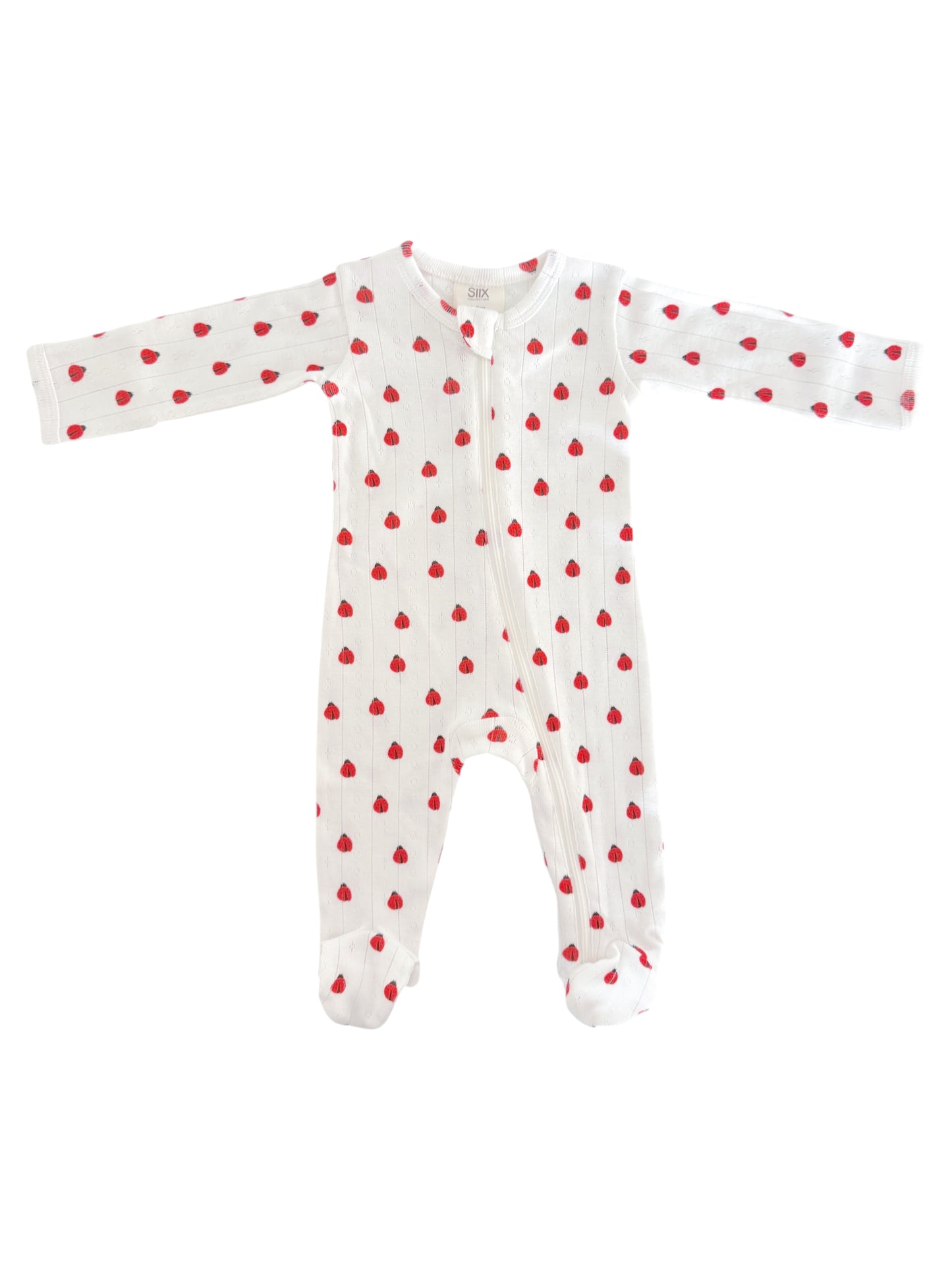 White baby onesie adorned with small red hearts, featuring long sleeves and a front zipper.