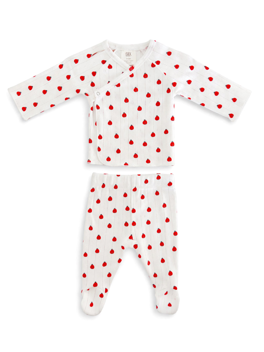 White baby outfit with red heart patterns, featuring long-sleeve top and footed pants.
