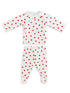 White baby outfit with red heart patterns, featuring long-sleeve top and footed pants.