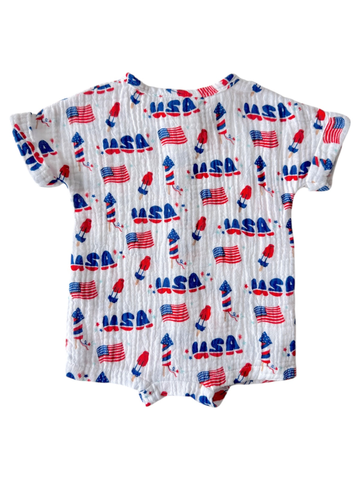 White baby onesie with colorful rockets and USA flags pattern. Ideal for patriotic occasions.